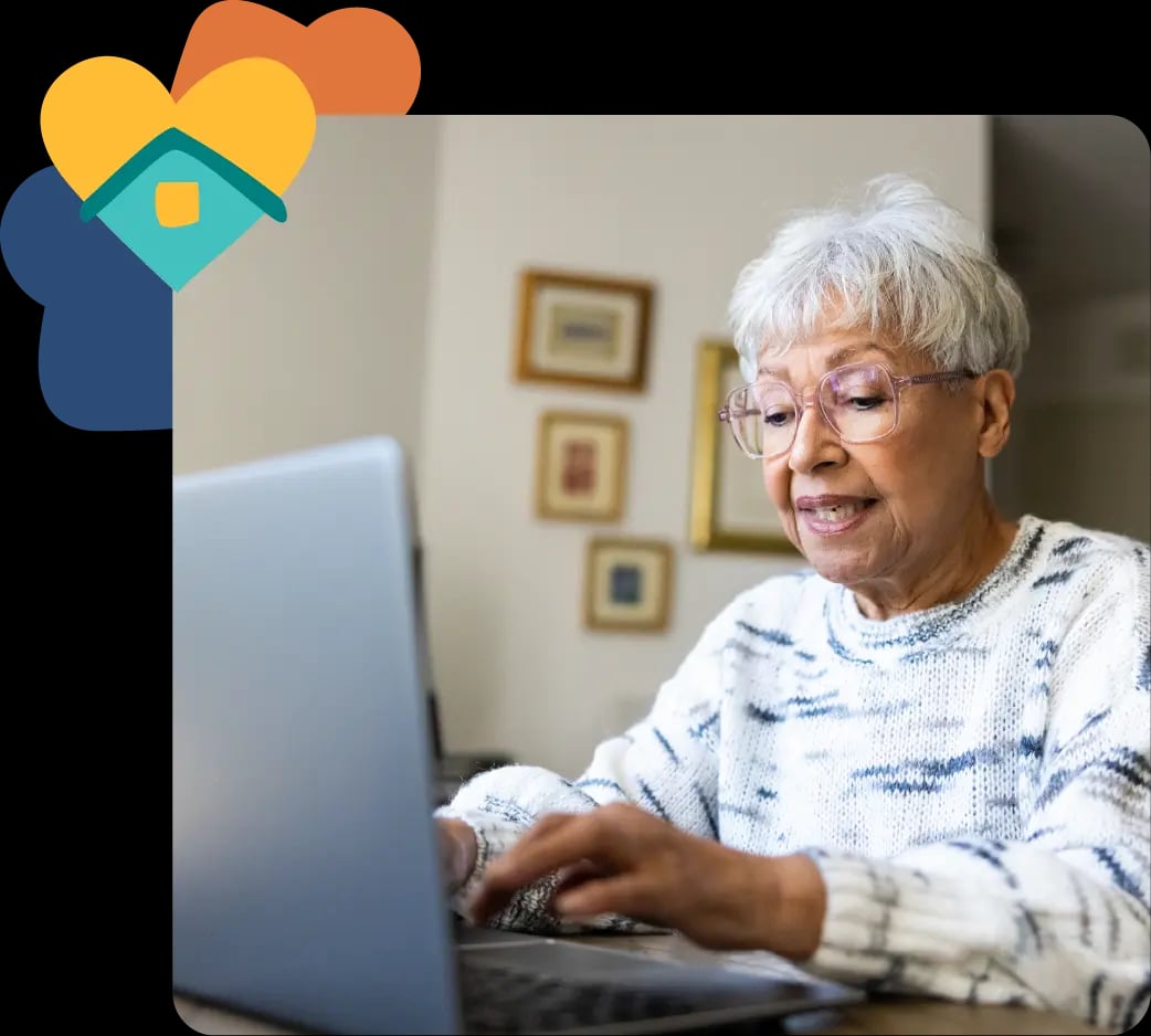 Image of older women using a laptop at home with a heart icon from Trilogy Care