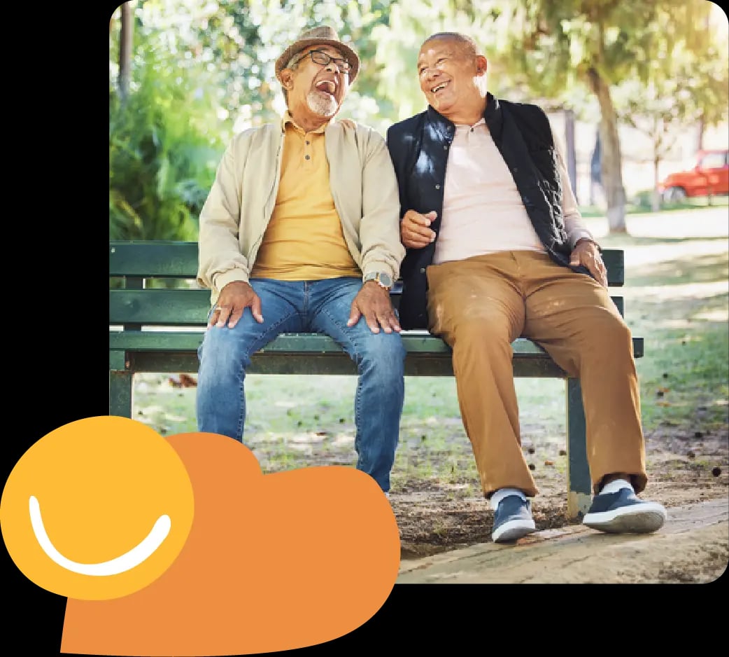 Dad and son sitting smiling on park bench