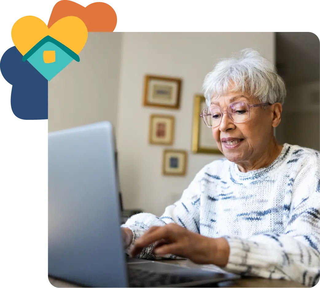 Image of older women using a laptop at home with a heart icon from Trilogy Care