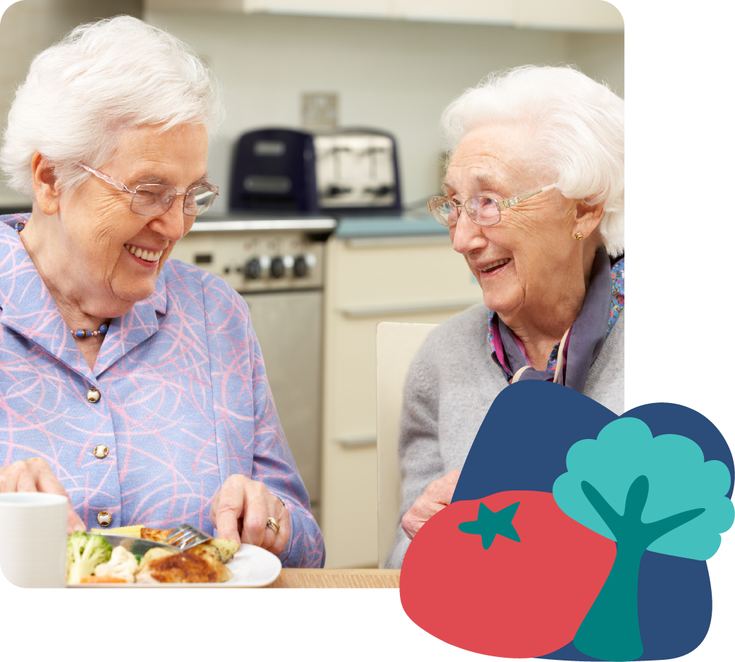 Two elderly women smiling and eating together in a kitchen, with house and tree icons displayed on the side