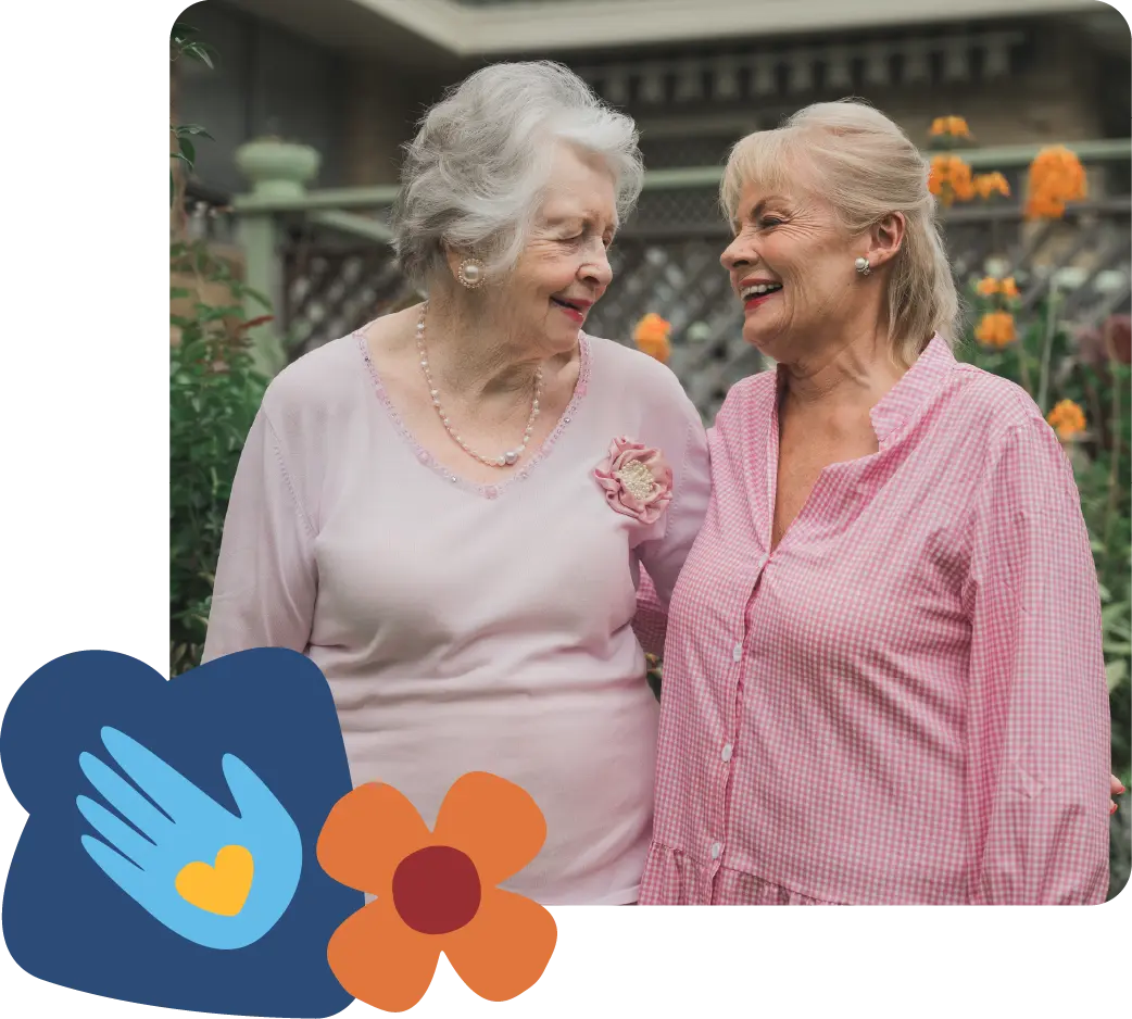 Paula Duncan and an elderly woman smiling in a garden, looking at each other, representing friendship and home care support