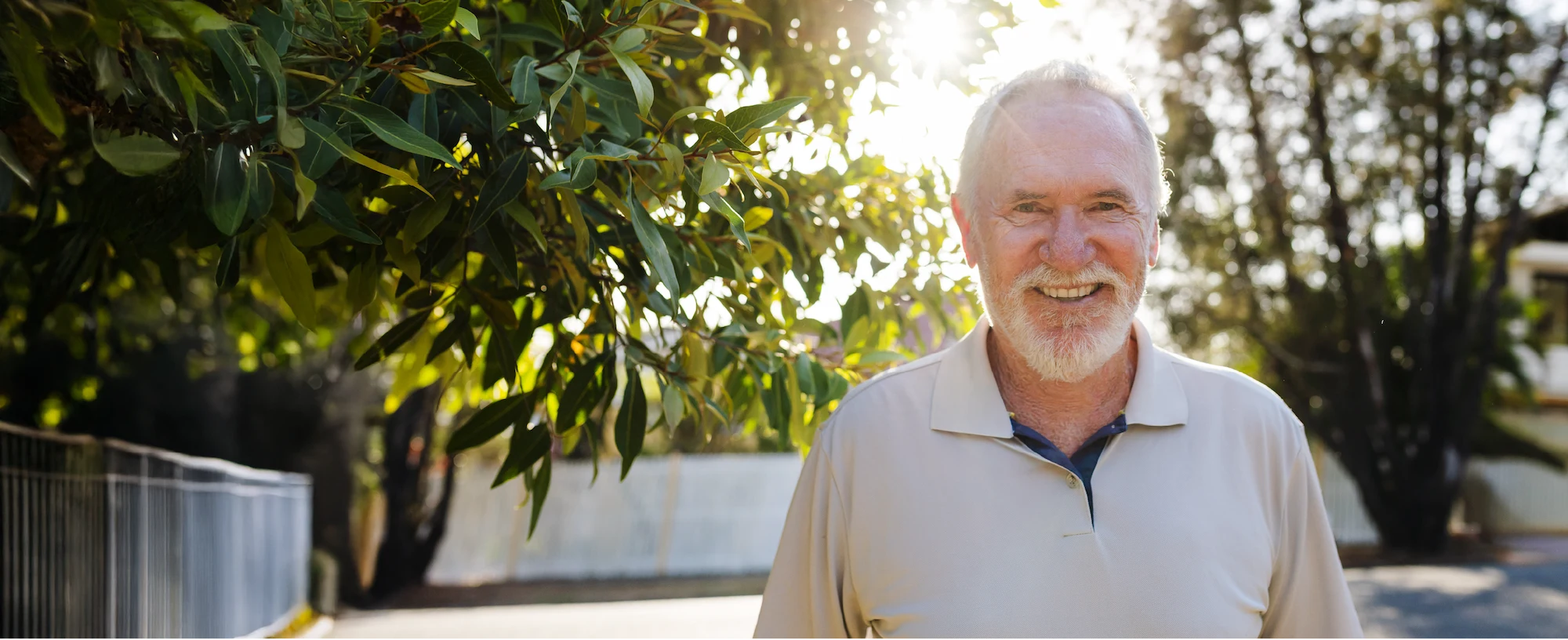 Allan Border, former Australian cricket captain, smiling in his backyard.