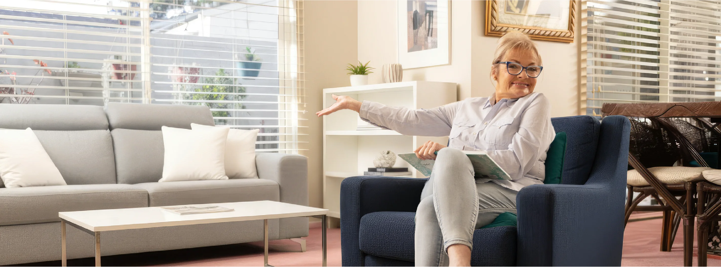Paula Duncan sitting on a sofa smiling, enjoying a relaxed moment