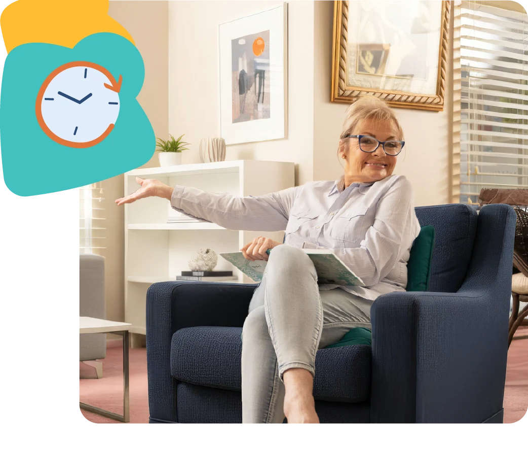 Paula Duncan sitting on a sofa smiling, enjoying a relaxed moment