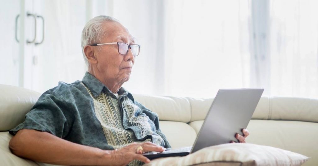 older man reading privacy policy on laptop
